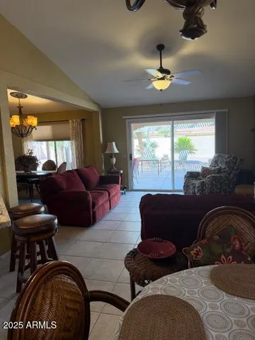 a living room with furniture a chandelier and a large window