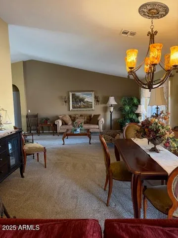 a living room with furniture a chandelier and a rug