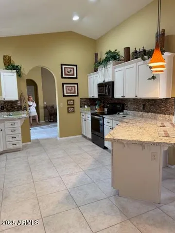 a kitchen with stainless steel appliances granite countertop a stove a sink and a refrigerator