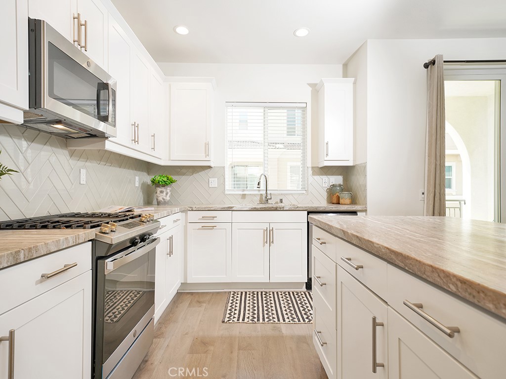 603 Shadowbrook Lake Forest, CA 92610 - Photo 9 of 23 a kitchen with stainless steel appliances granite countertop a stove a sink and a microwave