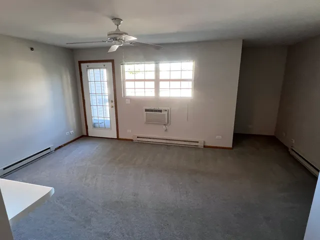 an empty room with windows and fan