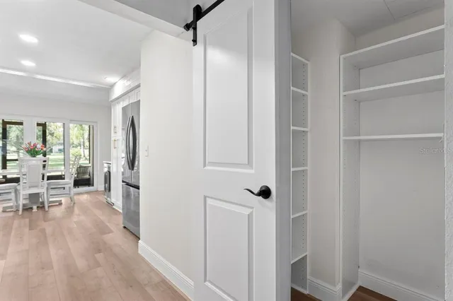a view of a hallway with wooden floor and furniture