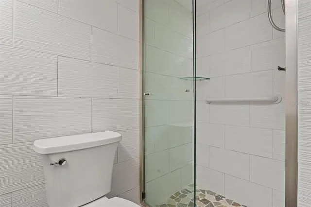 a white toilet sitting next to a shower