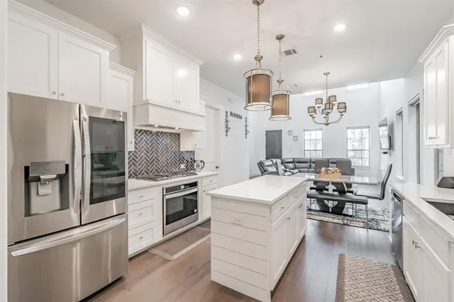 a kitchen with stainless steel appliances kitchen island granite countertop a stove and a sink
