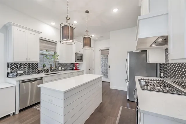 a kitchen with white cabinets and stainless steel appliances