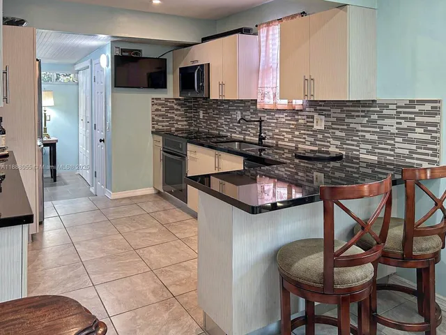 a kitchen with stainless steel appliances kitchen island granite countertop a stove a sink and a microwave