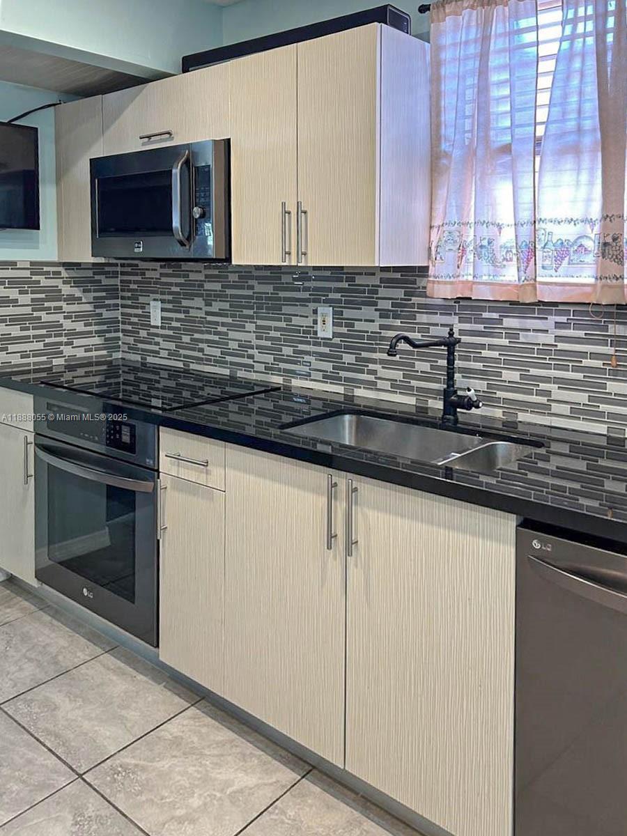 3410 Southwest 24th Street Miami, FL 33145 - Photo 6 of 8 a kitchen with stainless steel appliances granite countertop a sink and a microwave