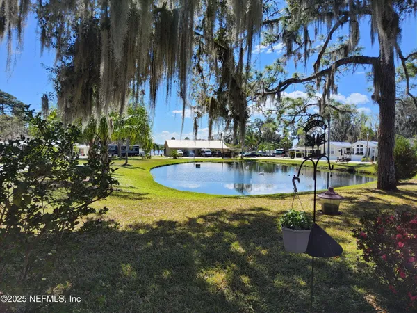 a view of a swimming pool with a lawn chairs under an umbrella
