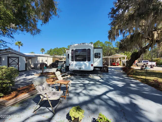 a view of a patio with table and chairs potted plants and a large tree
