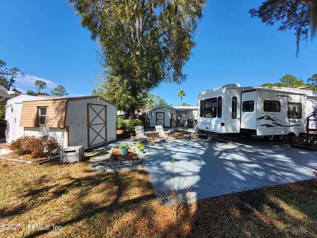 a view of a house with backyard and sitting area
