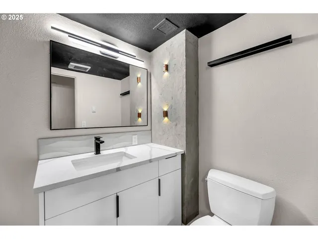 a bathroom with a sink toilet and mirror