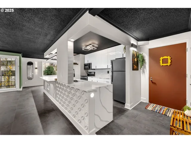a living room with stainless steel appliances kitchen island granite countertop furniture and a large window