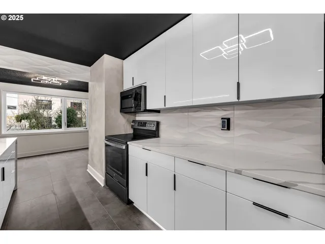 a kitchen with stainless steel appliances kitchen island granite countertop a sink a stove top oven and wooden floors