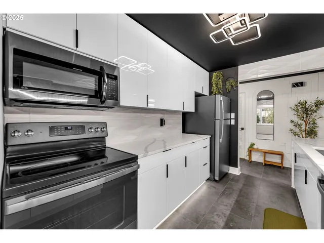 a kitchen with stainless steel appliances kitchen island granite countertop a stove a sink and a refrigerator