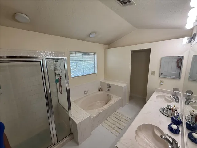 a bathroom with a tub sink and mirror