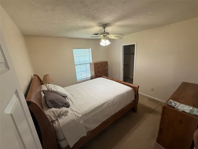 a bedroom with a bed and a ceiling fan