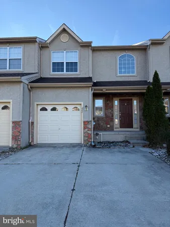 a front view of a house with a garage and a yard