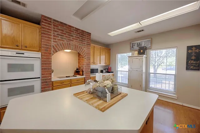 a living room with furniture appliances and wooden floor