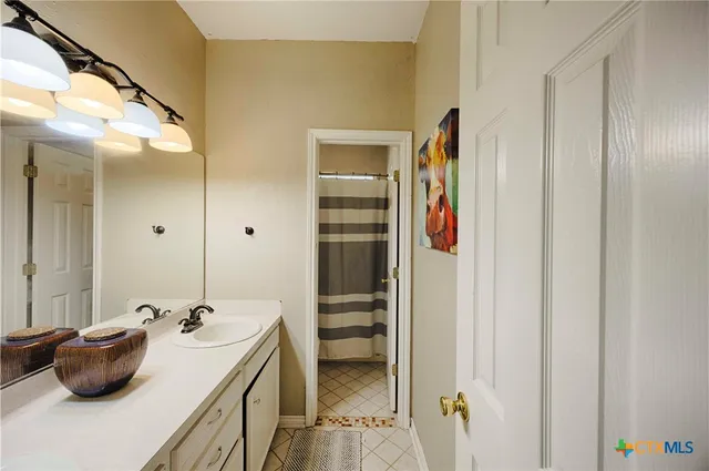 a spacious bedroom with a bed and a chandelier