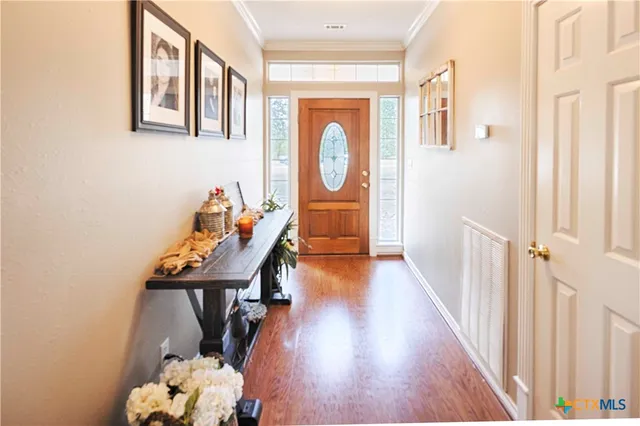 a view of a hallway with wooden floor and entryway