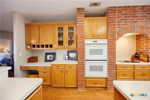 a view of kitchen with stainless steel appliances wooden floor and living room view