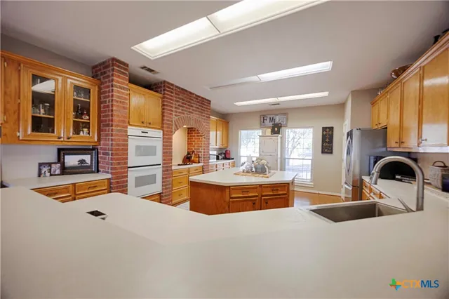 a kitchen with stainless steel appliances granite countertop a sink and a refrigerator