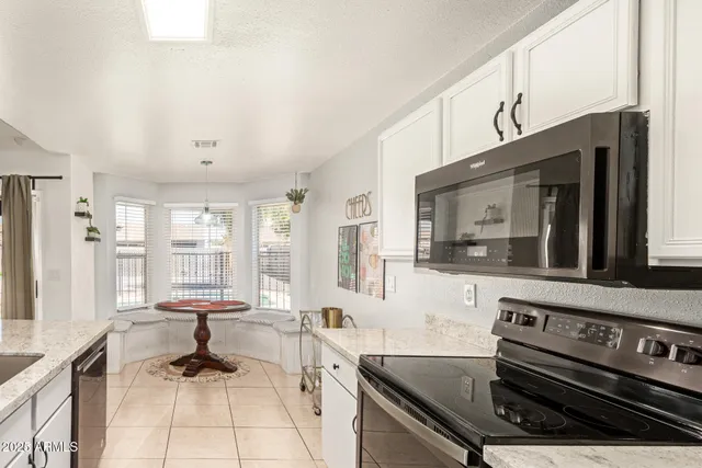 a living room with furniture a flat screen tv and a window