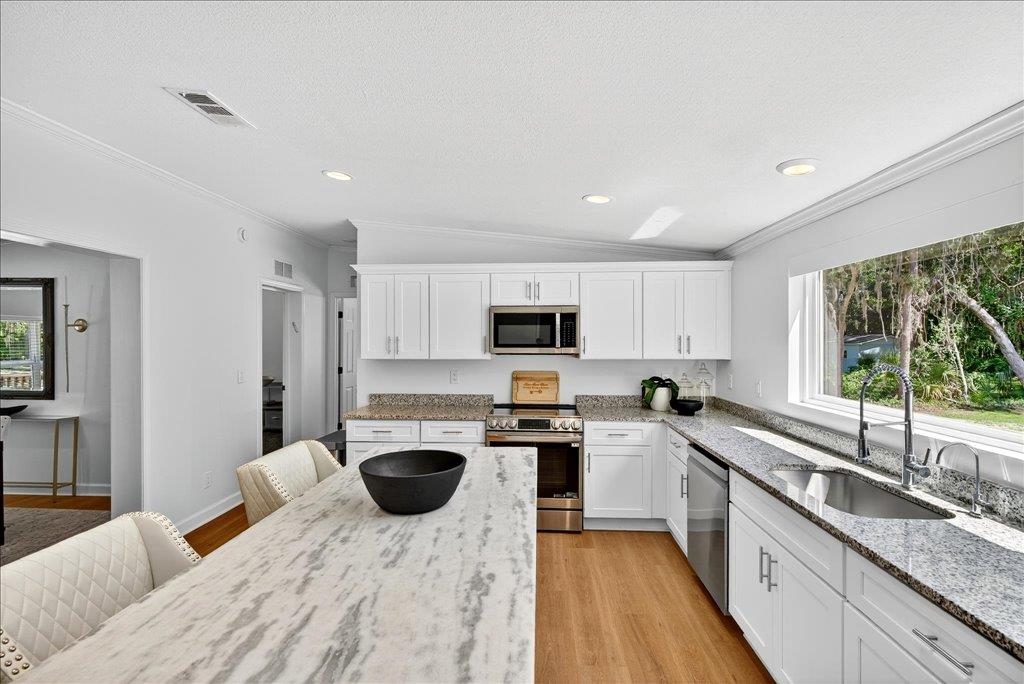 361 Coopers Cove Road St. Augustine, FL 32095 - Photo 11 of 35 a kitchen with kitchen island granite countertop a sink a counter top space stainless steel appliances and cabinets