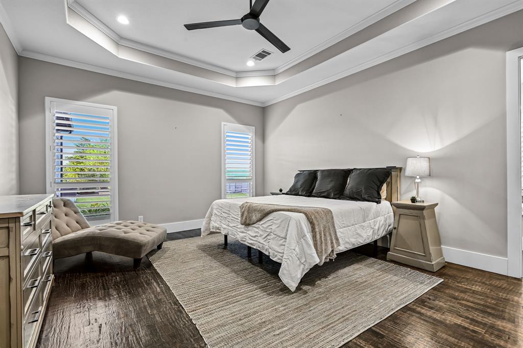 1070 Cornelius Road Rockwall, TX 75087 - Photo 14 of 33 Primary bedroom with recessed tray ceiling with crown molding and windows overlooking the back yard