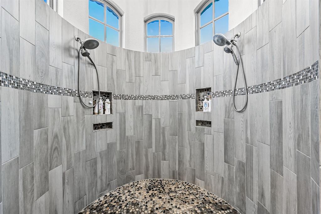 1070 Cornelius Road Rockwall, TX 75087 - Photo 18 of 33 Curved walk-in shower featuring dual shower heads and recessed shelving