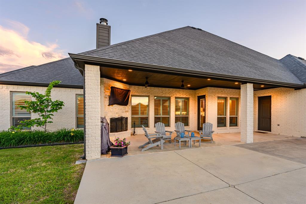 1070 Cornelius Road Rockwall, TX 75087 - Photo 4 of 33 Spacious covered patio featuring a built-in outdoor fireplace, recessed lighting, and ceiling fans
