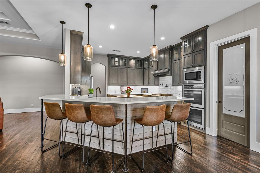 1070 Cornelius Road Rockwall, TX 75087 - Photo 9 of 33 Gourmet kitchen featuring an island with seating and a glass-paneled pantry door