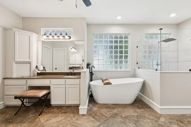 a spacious bathroom with a bathtub a sink and a window