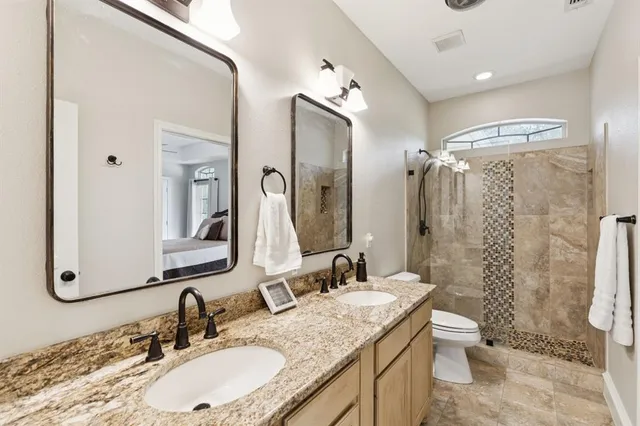 a bathroom with a granite countertop sink toilet and shower