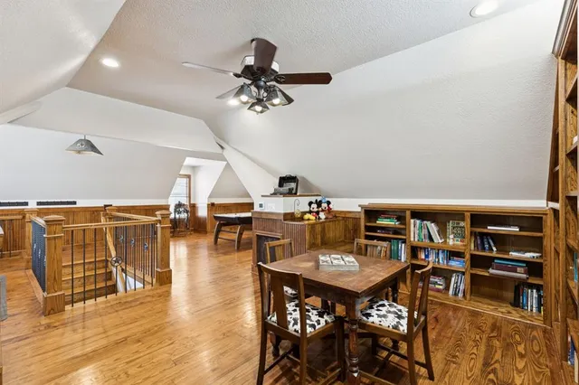 a room with wooden floor and pool table