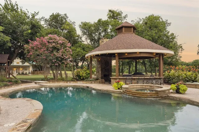 a view of house with swimming pool and a yard with green space
