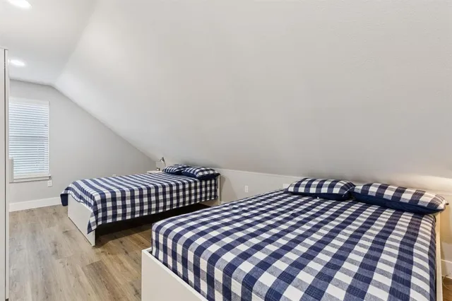 a bedroom with a bed and wooden floor