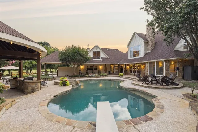 a view of a house with swimming pool and sitting area