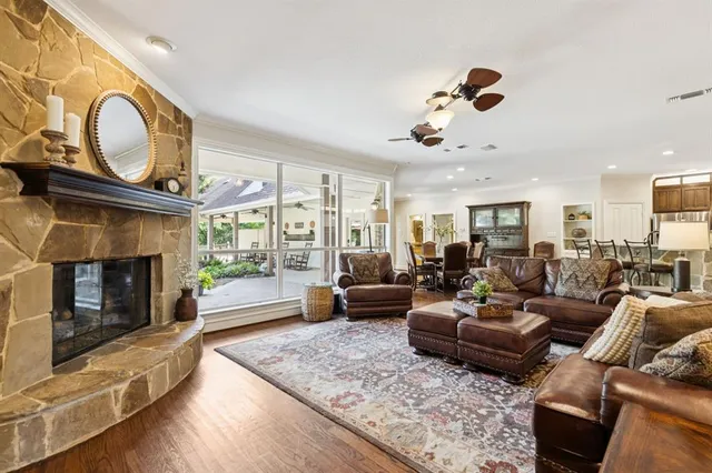 a living room with furniture a fireplace a rug and a window
