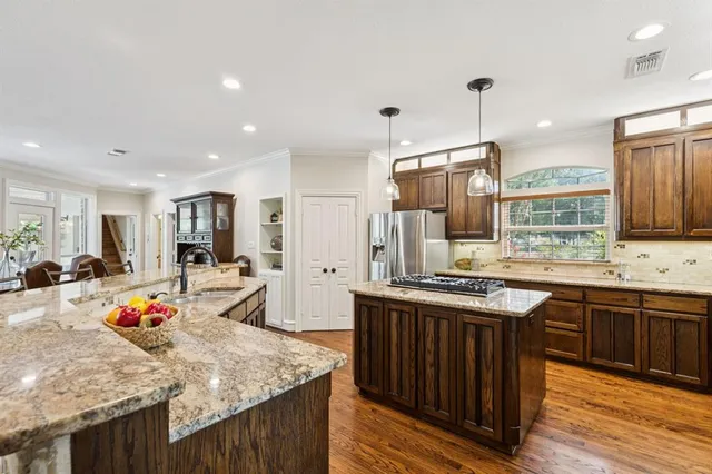 a kitchen with stainless steel appliances granite countertop a sink stove and refrigerator