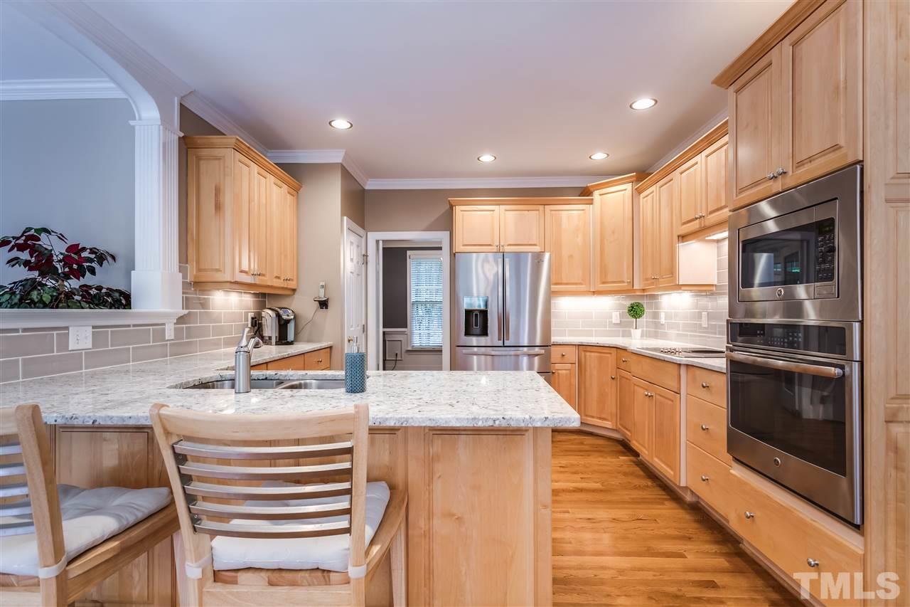9428 Macon Road Raleigh, NC 27613 - Photo 11 of 25 a kitchen with kitchen island granite countertop a stove and a sink
