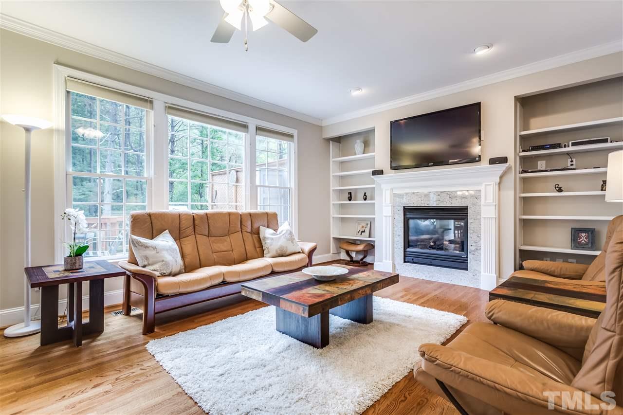 9428 Macon Road Raleigh, NC 27613 - Photo 16 of 25 a living room with furniture a flat screen tv and a fireplace