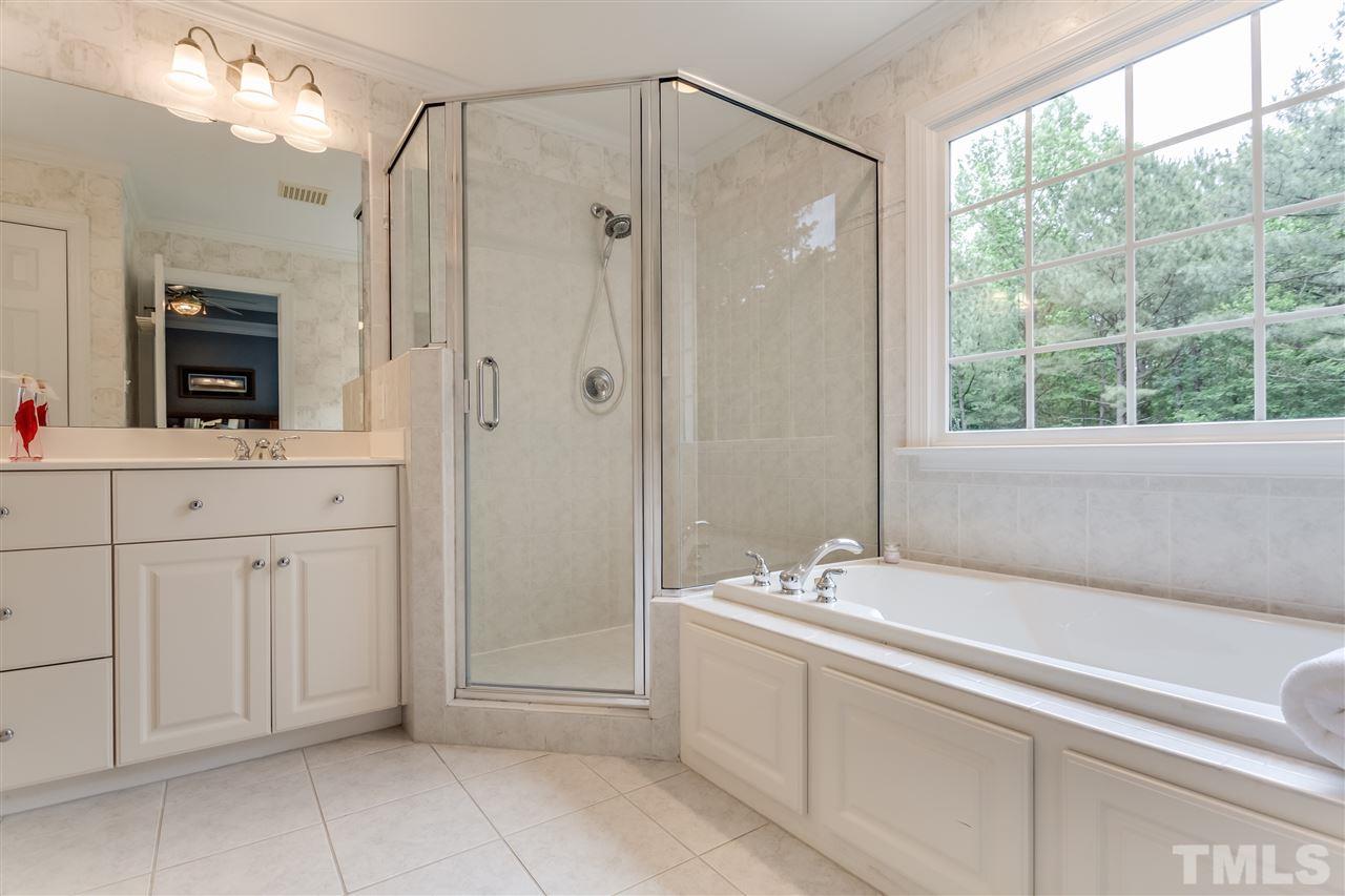 9428 Macon Road Raleigh, NC 27613 - Photo 20 of 25 a bathroom with a shower a sink and a mirror