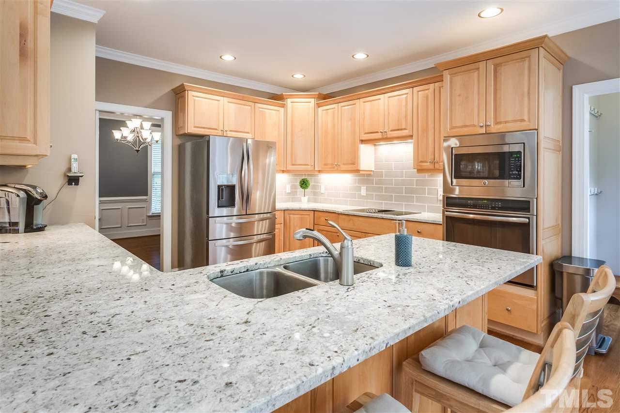 9428 Macon Road Raleigh, NC 27613 - Photo 9 of 25 a kitchen with stainless steel appliances granite countertop a refrigerator and a sink