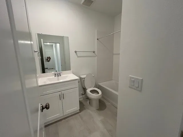 a bathroom with a toilet a sink and mirror