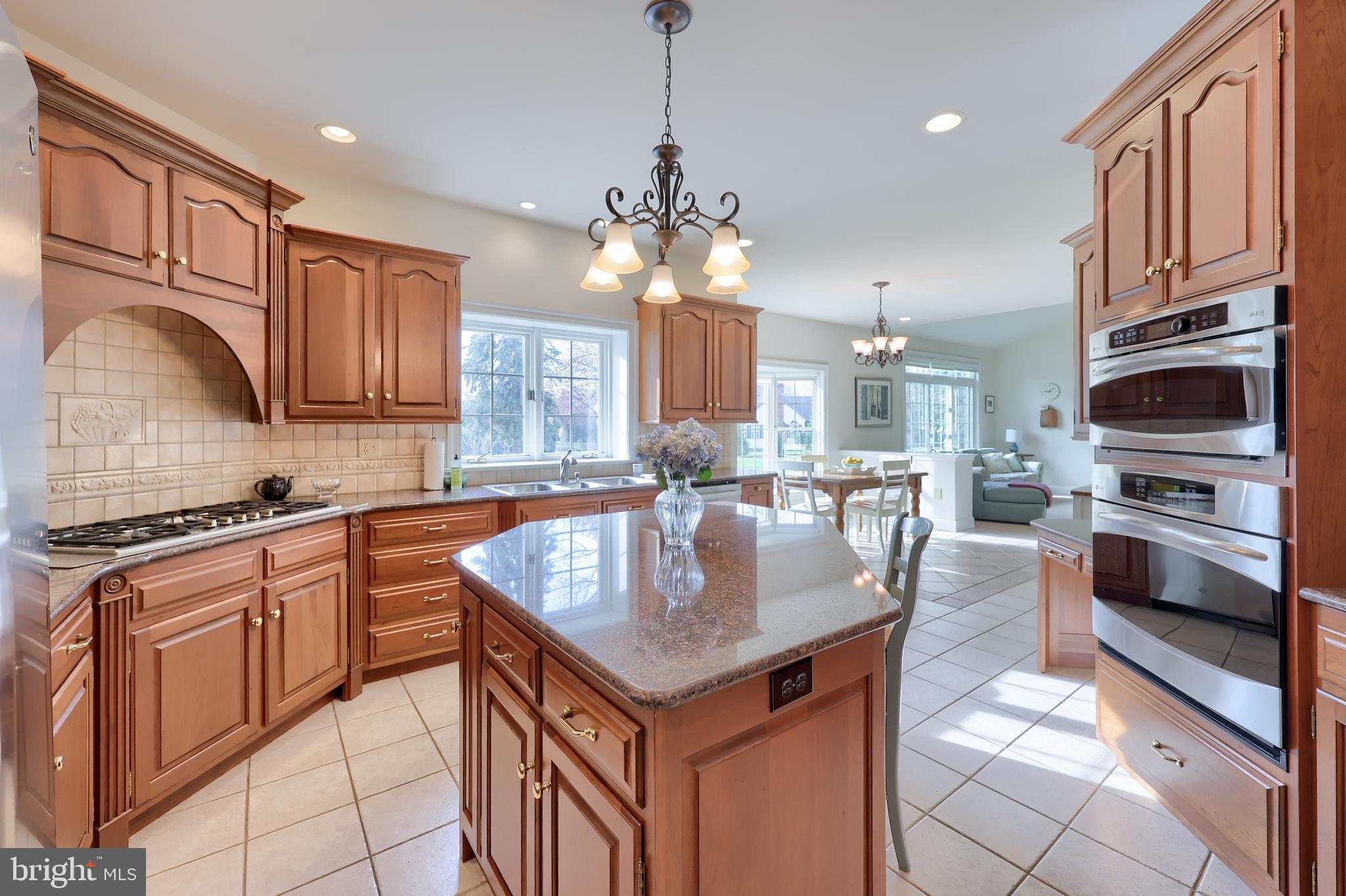 339 Harvest Drive Lititz, PA 17543 - Photo 24 of 69 a kitchen with stainless steel appliances granite countertop a stove top oven a sink dishwasher a dining table and chairs with wooden floor