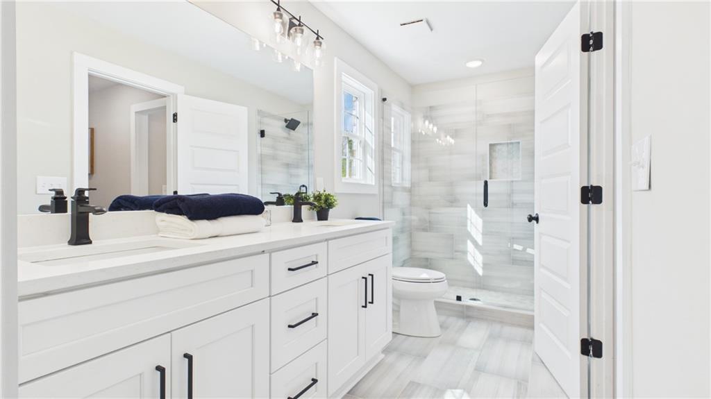 106 Neal Point Atlanta, GA 30349 - Photo 15 of 19 a bathroom with a double vanity sink toilet and shower