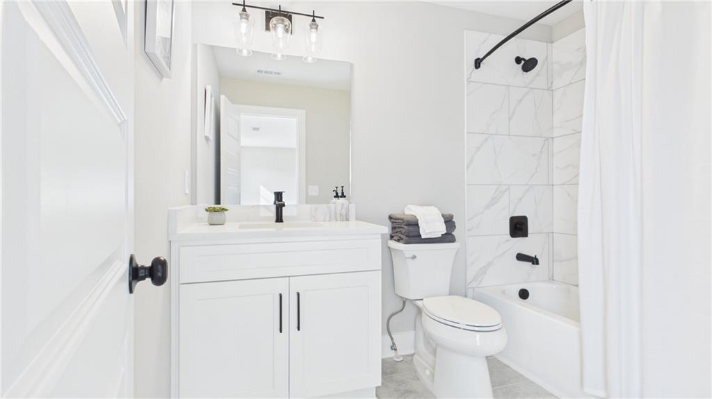 106 Neal Point Atlanta, GA 30349 - Photo 16 of 19 a bathroom with a sink a toilet and shower curtain