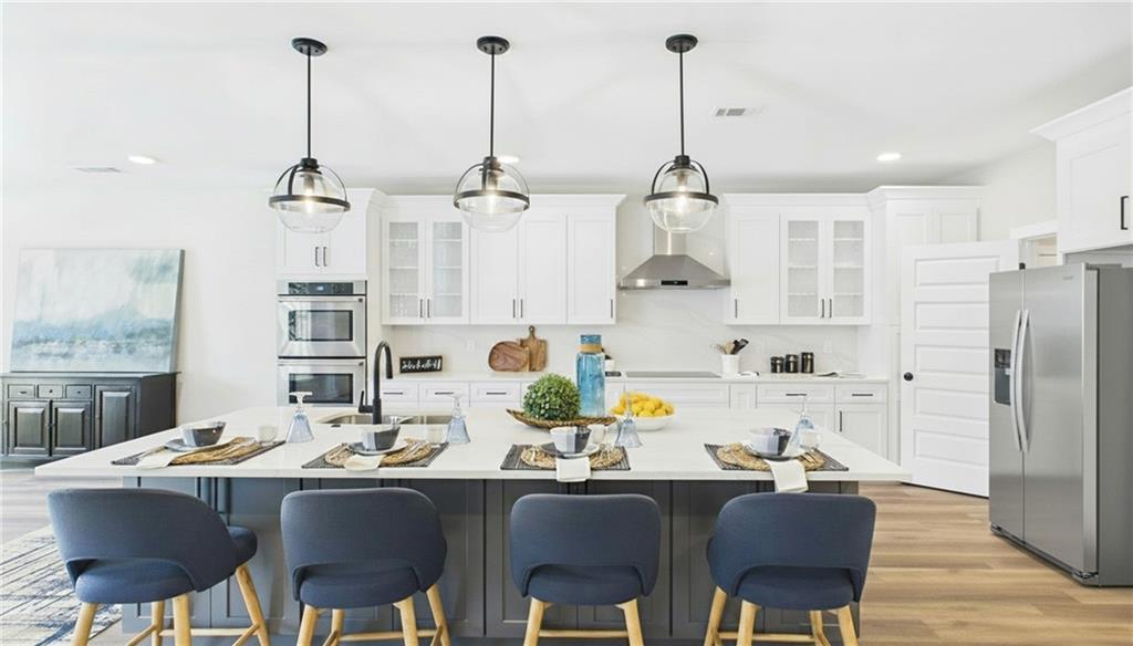 106 Neal Point Atlanta, GA 30349 - Photo 7 of 19 a dining room with stainless steel appliances kitchen island granite countertop a dining table chairs and a refrigerator