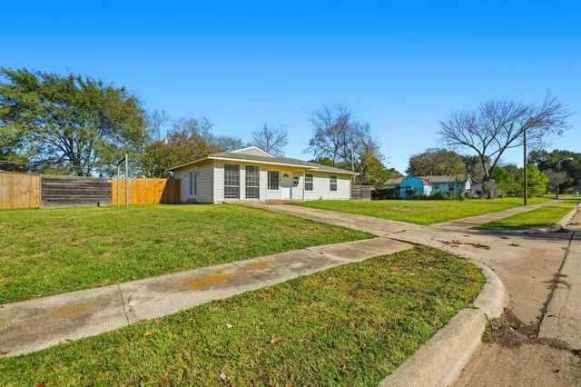 a view of an house with backyard and a tree